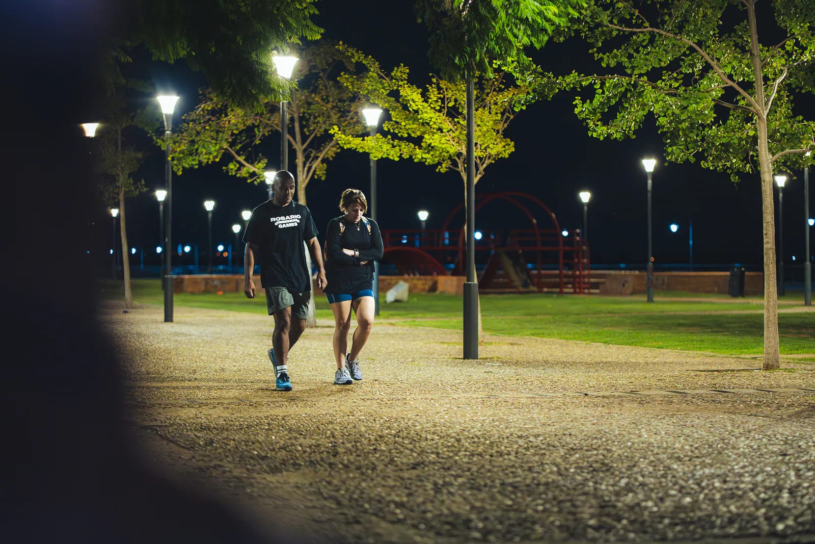Dos integrantes de Rosario Fitness Games caminando por la costa durante la noche